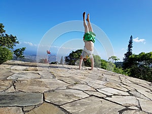 Man Handstanding on top mountain