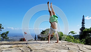 Man Handstanding on top mountain