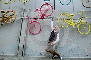 Man hanging on the art wall, holding himself in the air by a metal frame