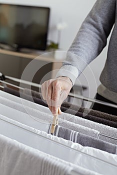 Man hanging clothes on a drying rack