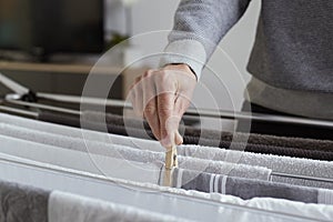 Man hanging clothes on a drying rack