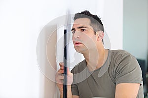 man hanging picture frame