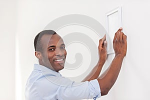 Man hanging picture frame.