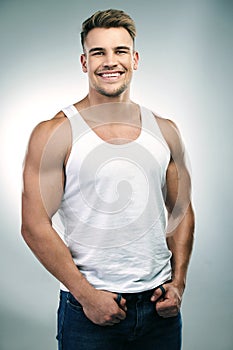 Man, happy and portrait in white background or funny with humour while joking in a tank top, fashion and wellness for photo