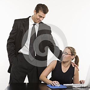 Man harassing woman at computer.