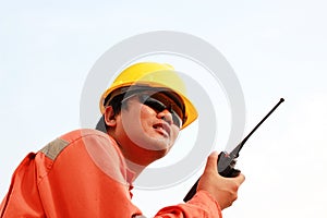 Man in hard hat using walkie talkie