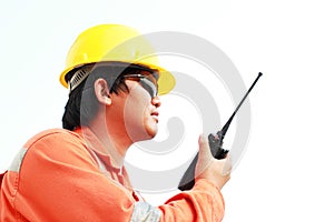 Man in hard hat using walkie talkie