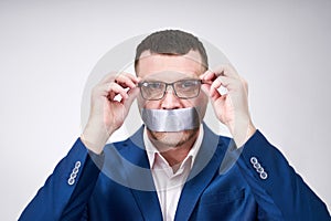 Man has a big piece of black industrial tape covering his mouth, silence concept