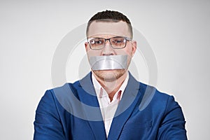 man has a big piece of black industrial tape covering his mouth, silence concept
