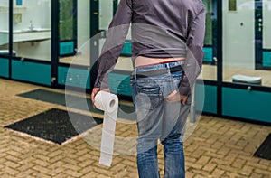 Man has diarrhea. Man holding toilet paper and his butt.