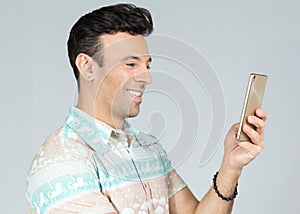 Man has fun using his cell phone. Handsome brazilian male wears