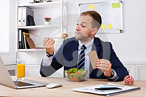 Man has healthy business lunch in modern office interior