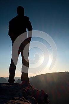 A man has his hands on hips. Sportsman silhouette in nature at daybreak.