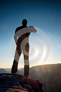 A man has his hands on hips. Sportsman silhouette in nature at daybreak.