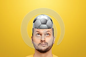 A man has a soccer ball in his head instead of a brain. Concept for cheerleader, sports betting, gambling, soccer betting