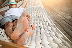 Man in hat in a hammock on a summer day