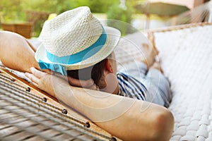 Man in hat in a hammock on a summer day