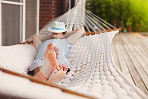 Man in hat in a hammock on a summer day