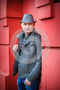 Man in a hat near the red wall