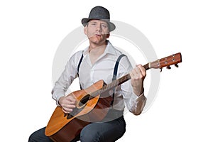 Man with hat plays acoustic guitar