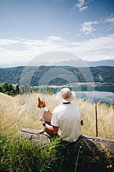 Man in hat sits with best friend dog puppy at top