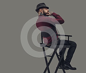 Man in hat sitting on film director`s chair.
