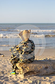 Man with hat sitting and looking at the ocean in Colombia