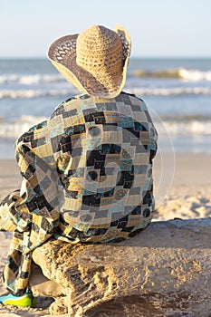 Man with hat sitting and looking at the ocean in Colombia