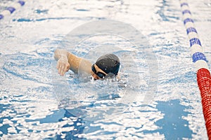 Man an in hat swimming in indoors swimming pool breaststroke photo