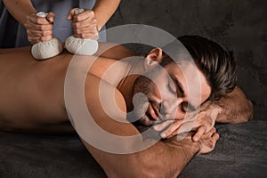 Man having back massage with pouche