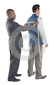 Man having back measured by tailor