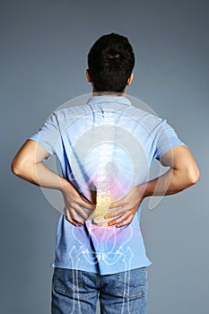 Man having backache on grey background. Digital compositing with illustration of spine