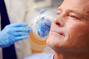 Man Having Botox Treatment At Beauty Clinic