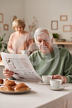 Man having breakfast with newspaper