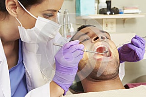 Man Having Check Up At Dentists Surgery