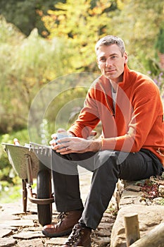 Man Having Coffee Break Whilst Working Outdoors