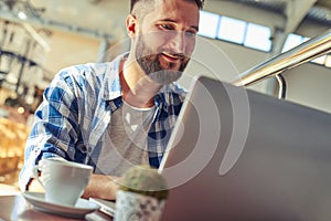 Man having coffee break and working with laptop