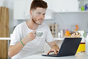 man having coffee while working on notebook