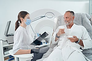 Man having consultation with doctor in cosmetology clinic