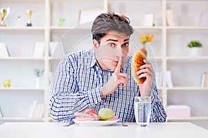 Man having dilemma between healthy food and bread in dieting con