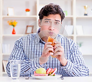 Man having dilemma between healthy food and bread in dieting con