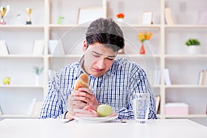 Man having dilemma between healthy food and bread in dieting con