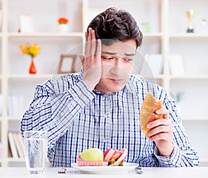 Man having dilemma between healthy food and bread in dieting con