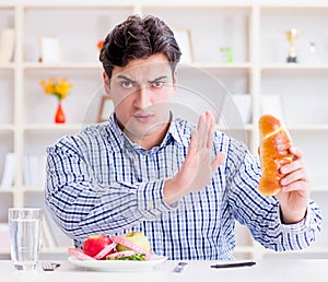 Man having dilemma between healthy food and bread in dieting con