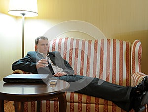 Man having drink on sofa