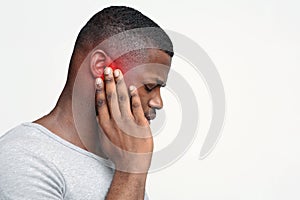 Man having ear pain, touching his painful head