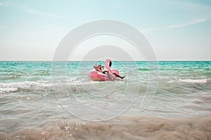 Man is having fun on pink flamingo inflatable pool float
