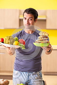 The man having hard choice between healthy and unhealthy food