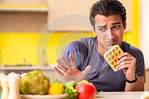 The man having hard choice between healthy and unhealthy food