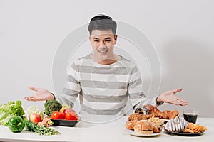 Man having hard choice between healthy and unhealthy food